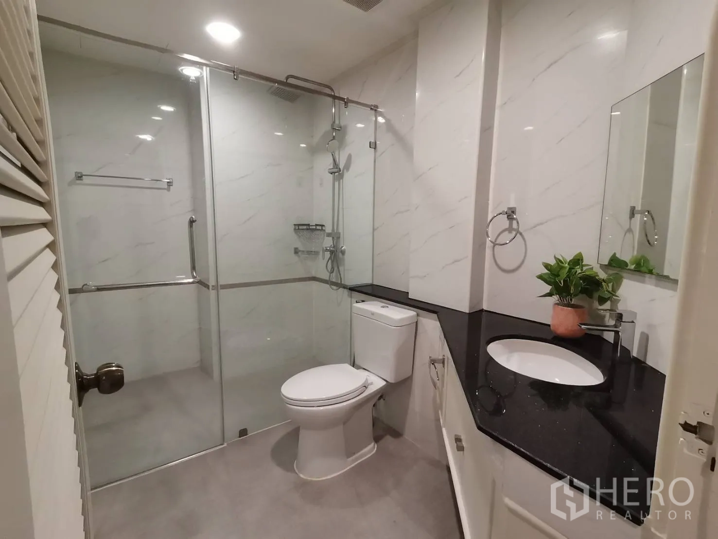 公寓 for rent in Watthana, Bangkok - 现代浴室，玻璃淋浴房、坐便器、黑色台面长洗手台与镜子。