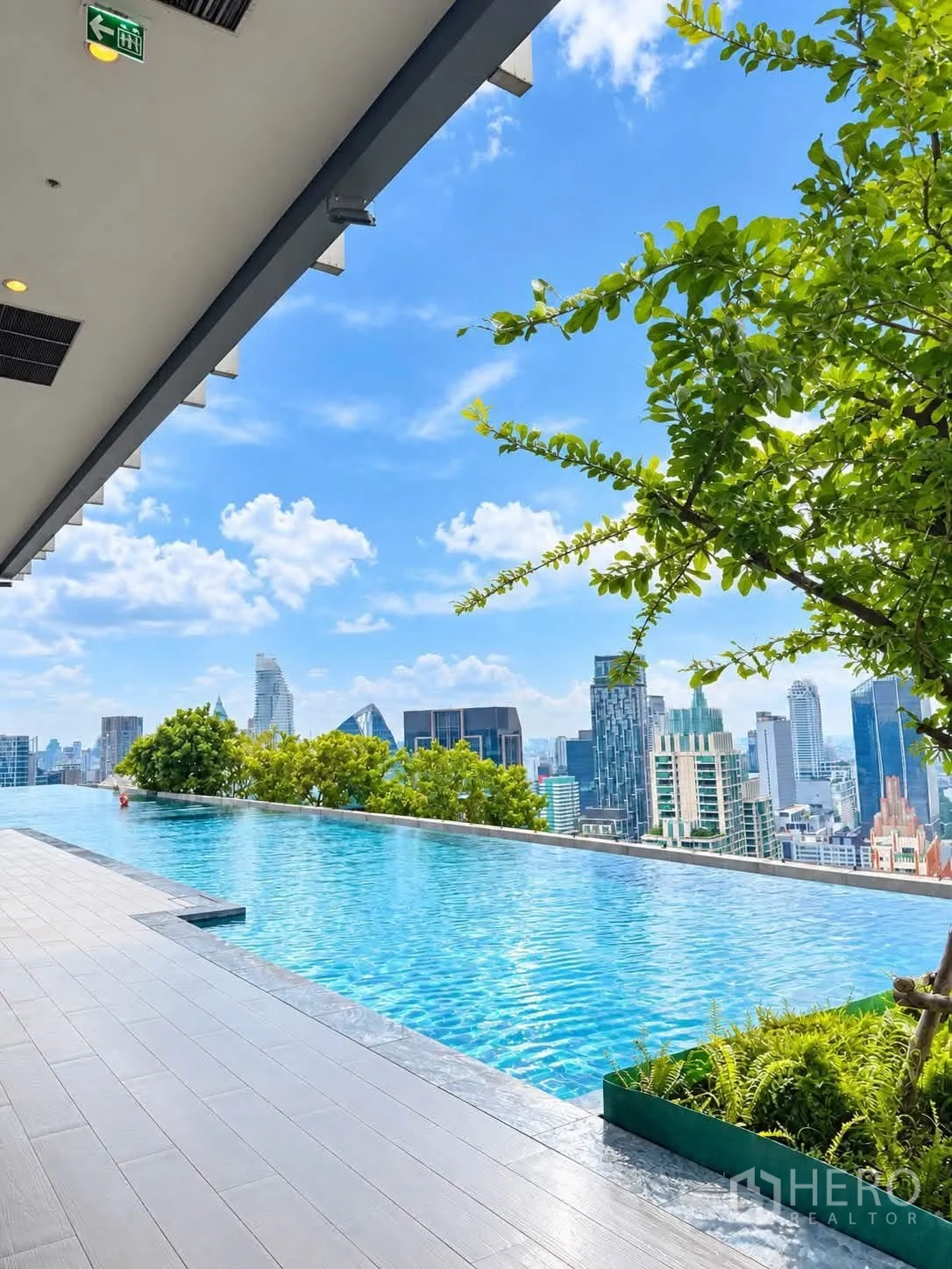 Condominium for rent in Pathum Wan, Bangkok - Rooftop infinity pool overlooking the Bangkok skyline under a blue sky.