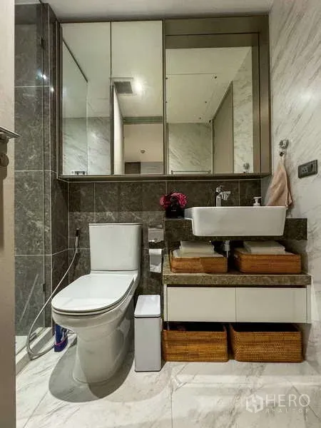 Condominium for rent - Modern bathroom with glass shower, vessel sink, mirrored cabinets and stone tiles.