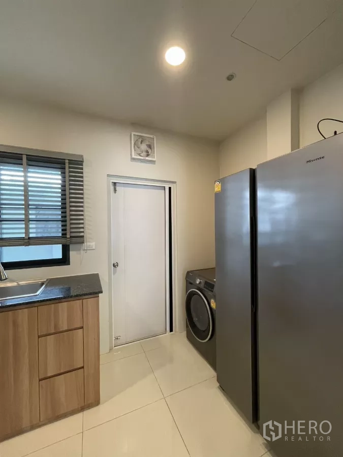 独立式住宅 出租在Bang Phli, Samut Prakan - 厨房角落设双门冰箱和洗烘一体机。