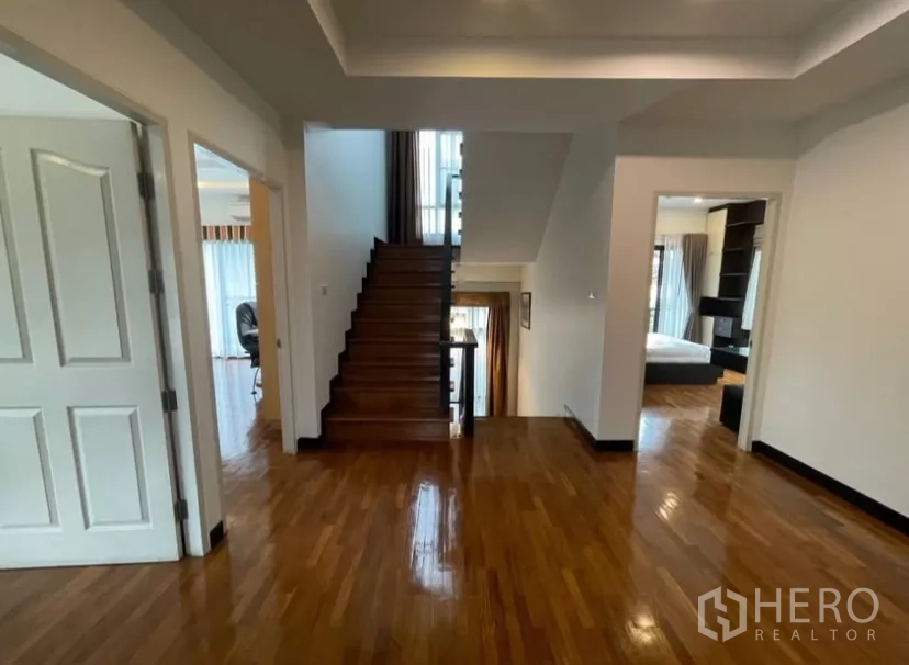 Detached House for rent in Chatuchak, Bangkok - Upper landing with polished wooden floors and staircase connection.