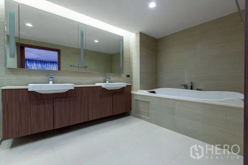 Condominium for rent or sale - Contemporary bathroom with double vanity, large mirror and built-in soaking tub.