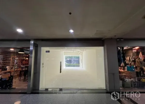Retail Space for rent in Watthana, Bangkok - Front view of an empty white-box retail space with full-height glass doors between neighboring shops.