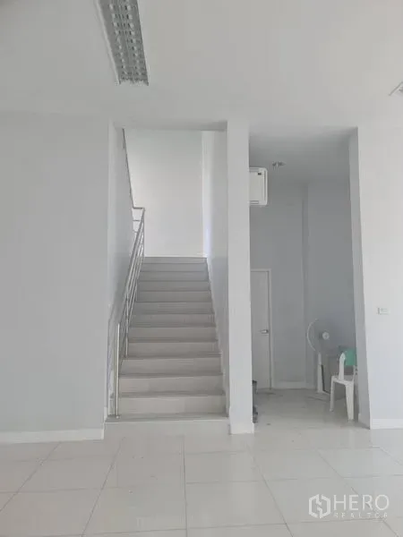 工厂 出租或出售在Lam Luk Ka, Pathum Thani - 一层大堂明亮，白色地砖与中央楼梯。