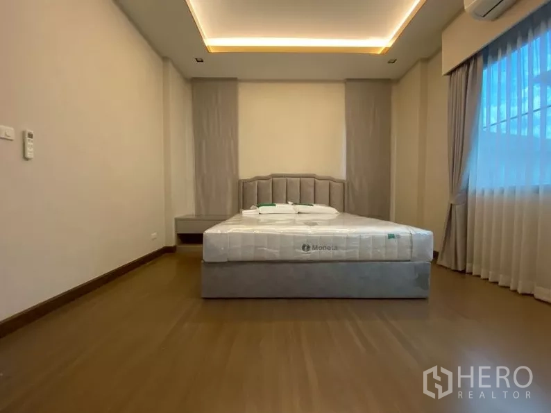 独立式住宅 出租在Prawet, Bangkok - 主卧以中性色调，软包床头与宽窗。