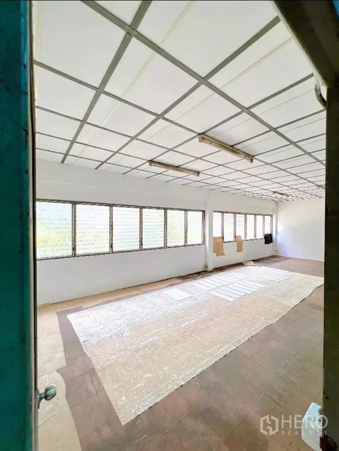 Factory for rent in Sai Noi, Nonthaburi - Bright upper-floor office room with long louvered windows.