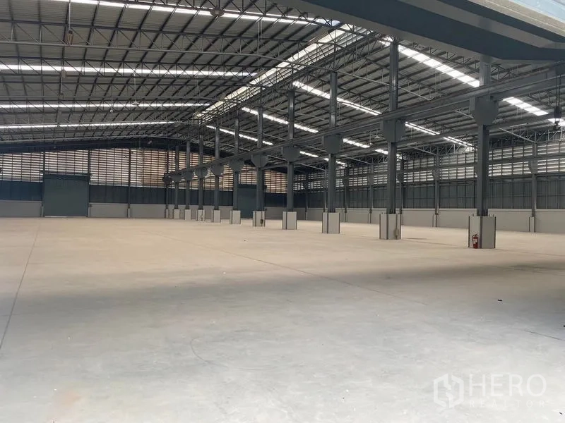 Warehouse for rent in Bang Phli, Samut Prakan - Wide interior shot of warehouse bays showing ventilation louvers, clear‑span roof and generous floor area.