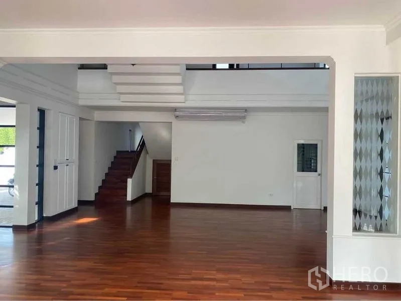 บ้าน ให้เช่าในWatthana, Bangkok - ห้องนั่งเล่นกว้าง พื้นไม้ บันได และแอร์แขวนผนัง