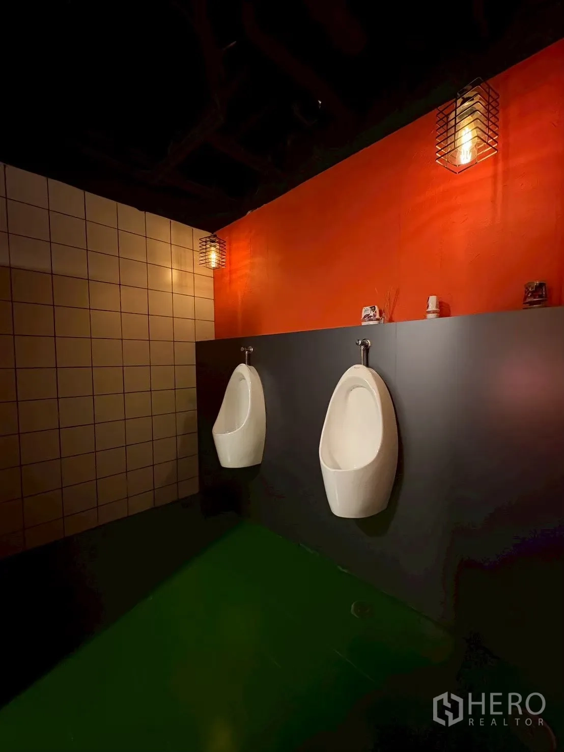 Office Space for rent in Khlong Toei, Bangkok - Wall-mounted urinals against an orange accent wall with industrial lighting.