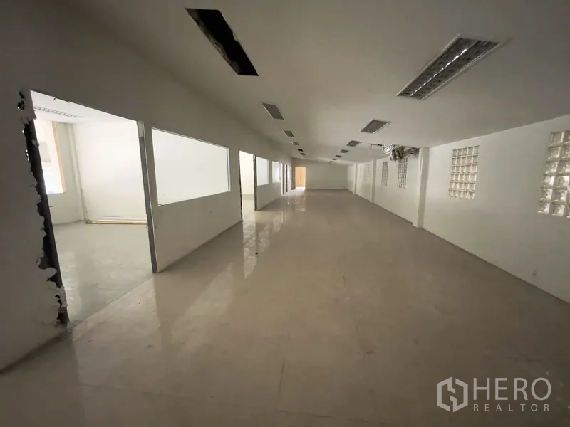 Warehouse for rent in Prawet, Bangkok - Deep office floor with multiple rooms and interior windows.