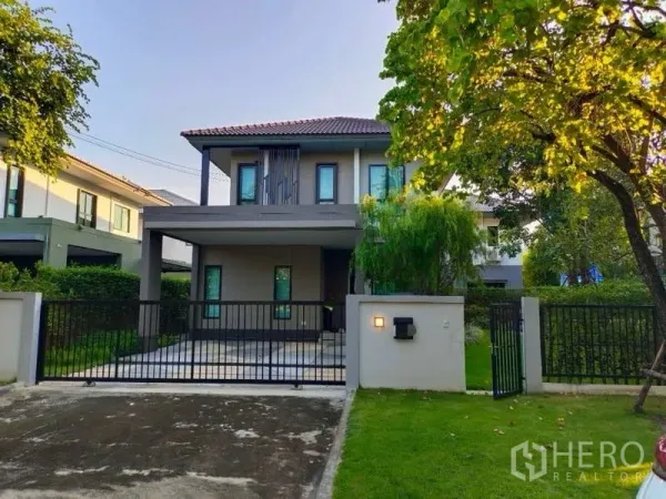 บ้าน ให้เช่าในBang Phli, Samut Prakan - ด้านหน้าบ้านเดี่ยวสองชั้นในบางพลี พร้อมรั้วและลานจอดรถ สนามหญ้า
