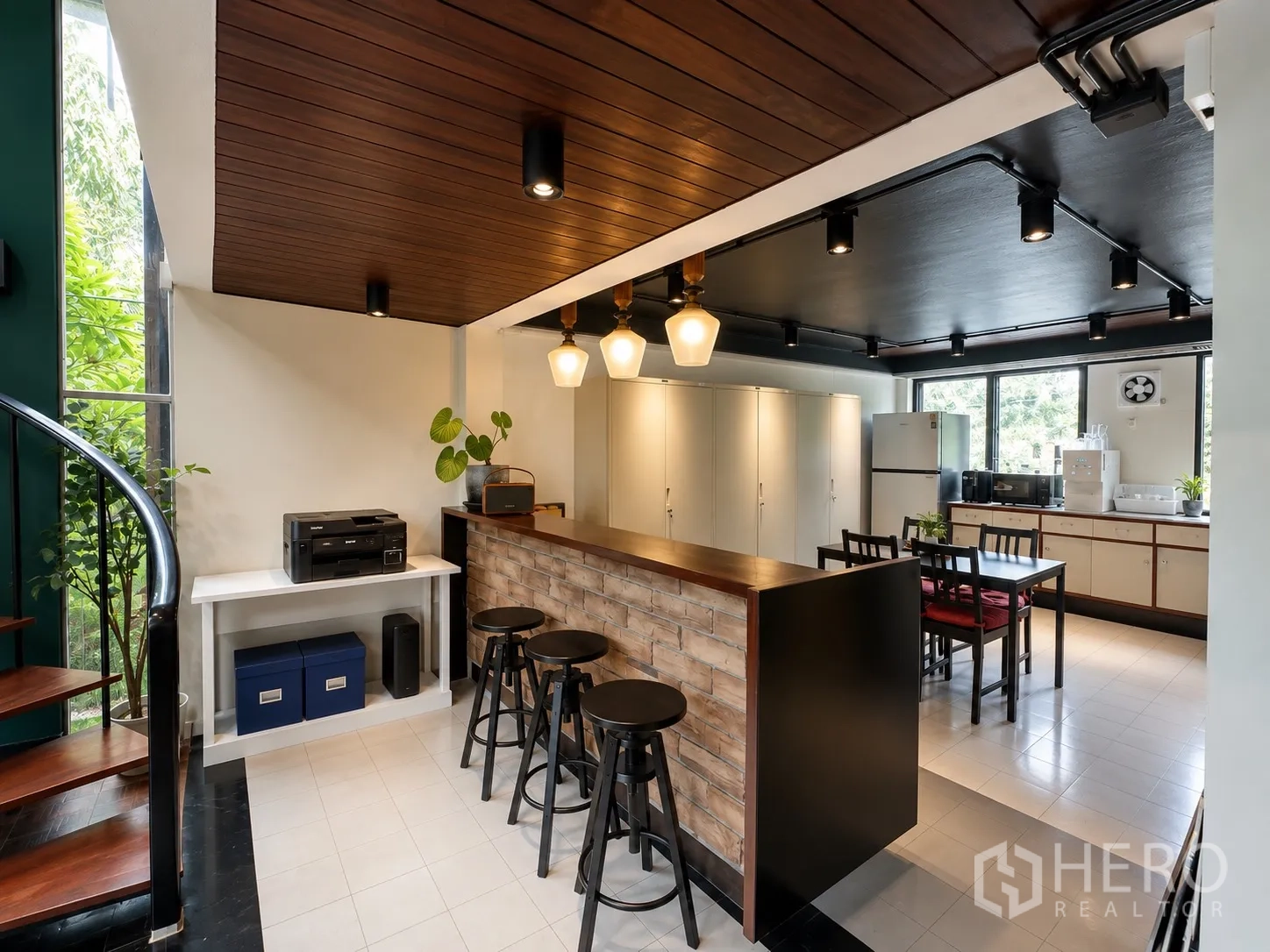 Office Space for rent in Phaya Thai, Bangkok - Pantry with brick-front bar, black stools, cabinets, and appliances beside a spiral staircase.