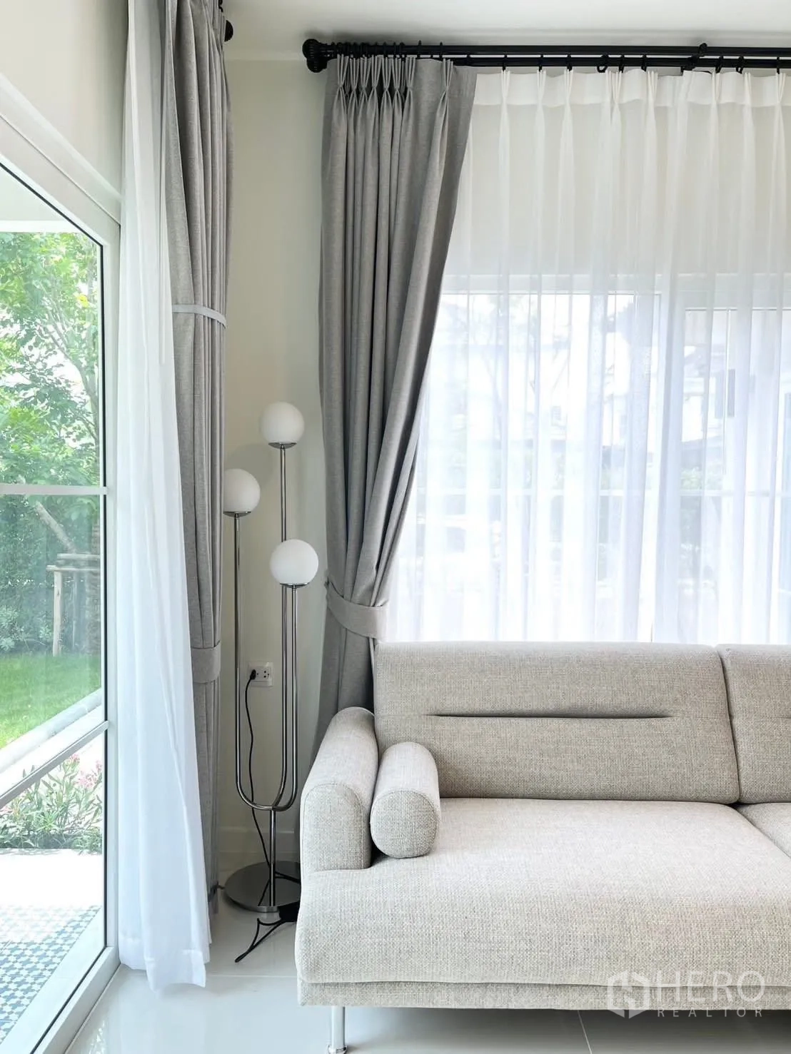 บ้านเดี่ยว for rent in Bang Phli, Samut Prakan - โซฟารับแขกข้างหน้าต่างสูง โคมไฟตั้งพื้น และมุมมองสวน.