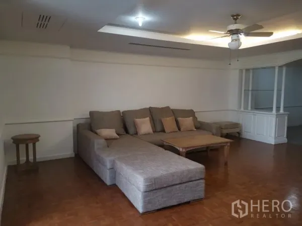 คอนโด ให้เช่าในWatthana, Bangkok - ห้องนั่งเล่นกว้าง โซฟาเข้ามุมตัวใหญ่ พัดลมเพดาน และพื้นปาเกต์