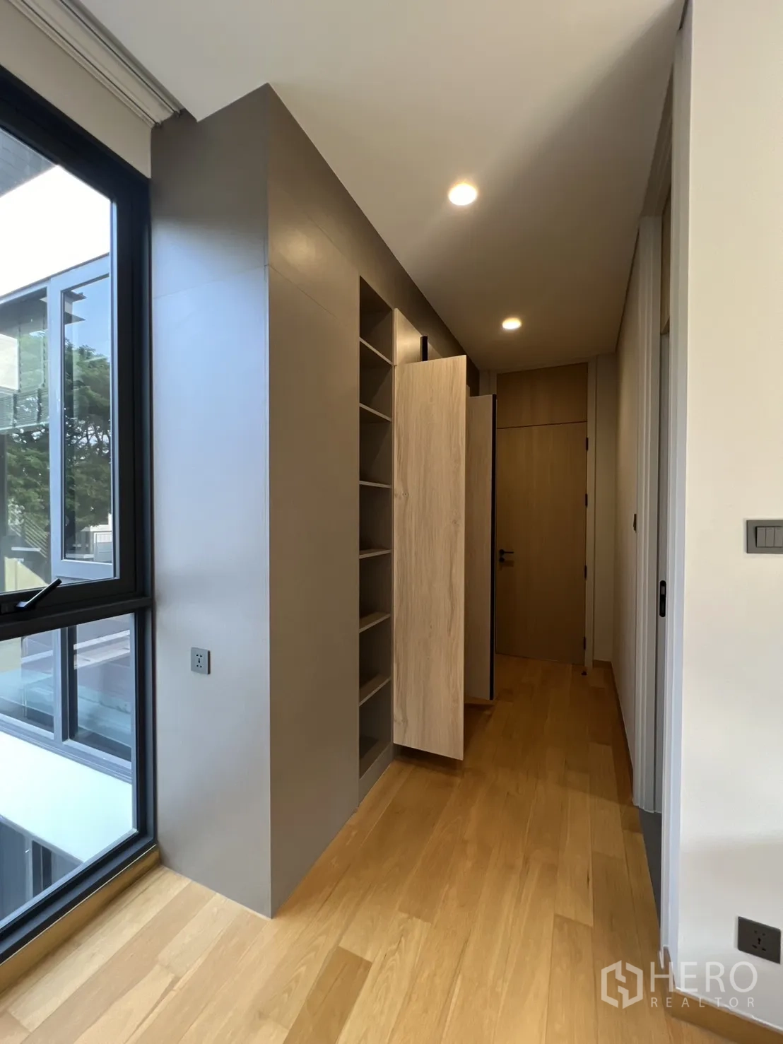 Detached House for rent in Suan Luang, Bangkok - Hallway storage with tall built‑in cabinets beside a picture window.