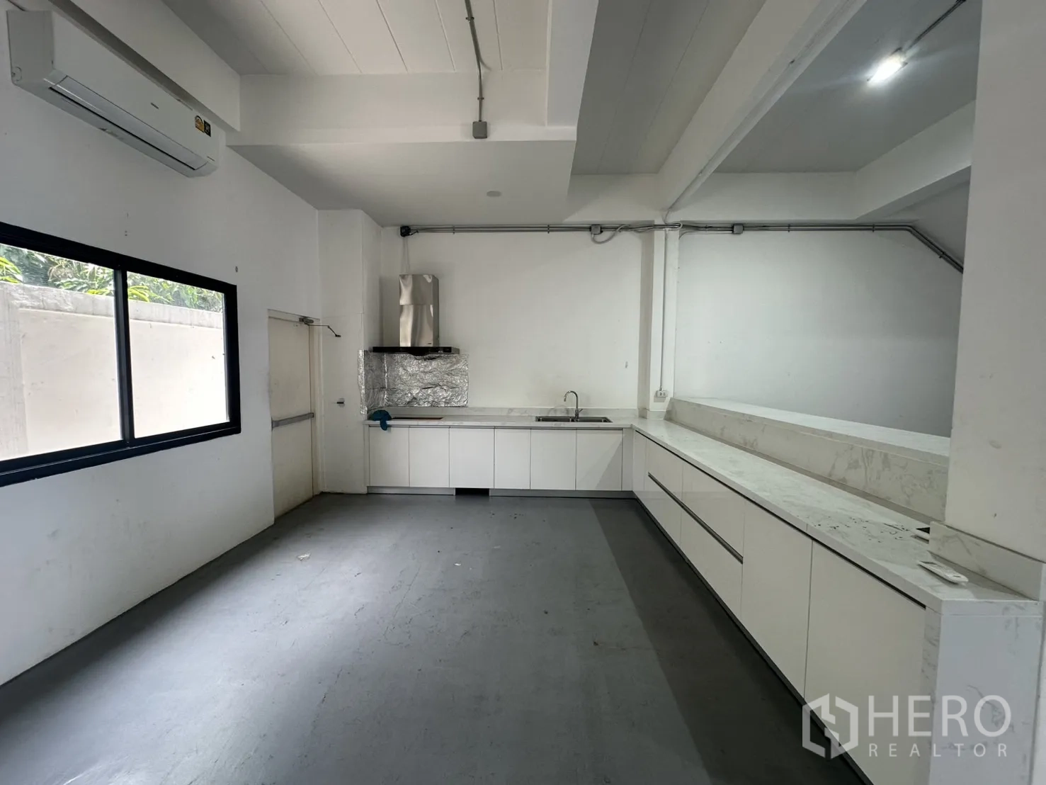 Home Office for rent or sale in Bang Na, Bangkok - L-shaped white pantry with long marble-look countertop and extractor hood.