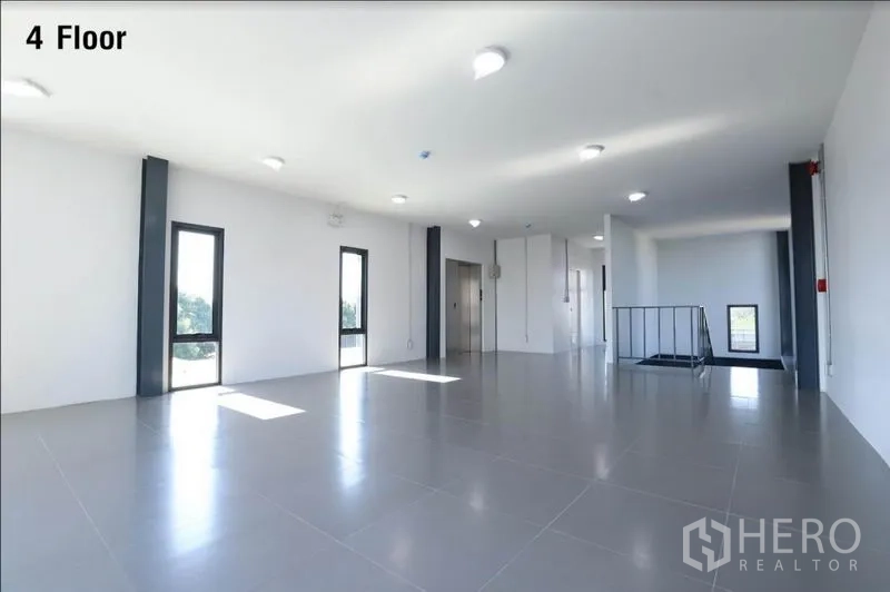 Warehouse for rent in Wang Thonglang, Bangkok - Bright fourth-floor office area with large windows and elevator access.