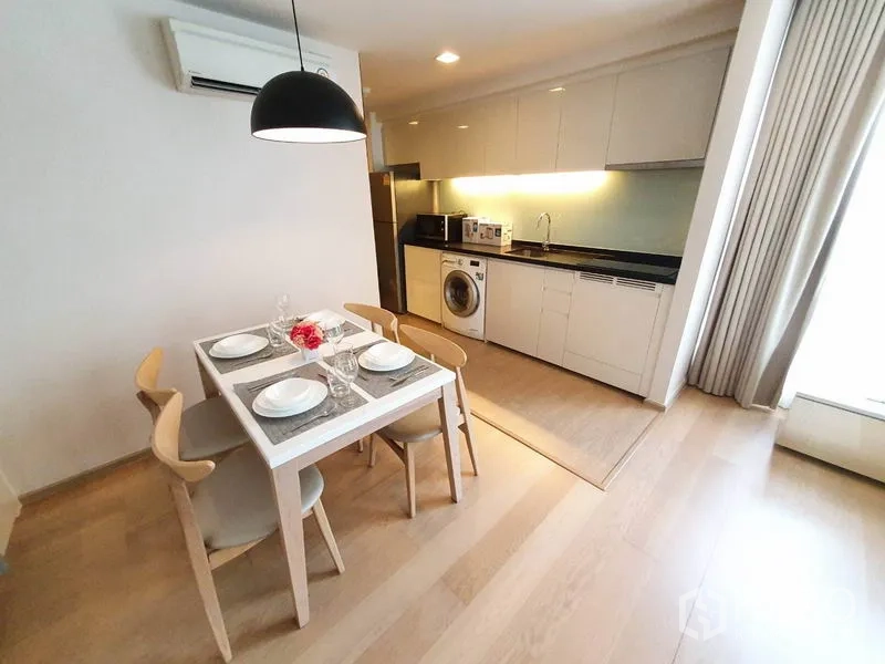 公寓 出租在Watthana, Bangkok - 明亮用餐区，旁为带吊柜和洗衣机的厨房