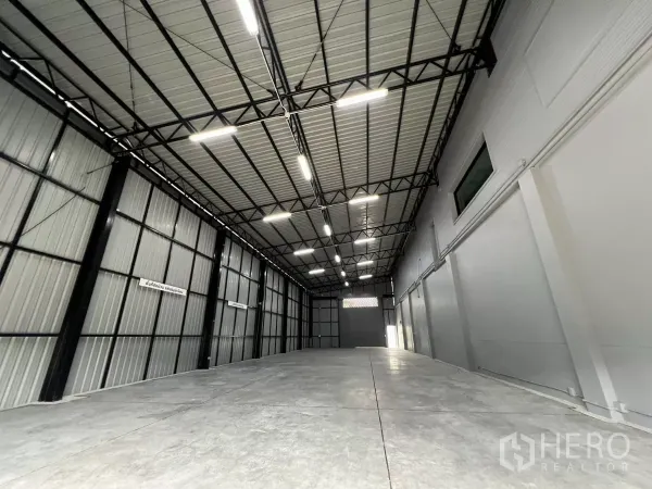 Warehouse for rent in Yan Nawa, Bangkok - High-ceiling warehouse interior with steel truss roof, bright LED lights and smooth concrete floor.