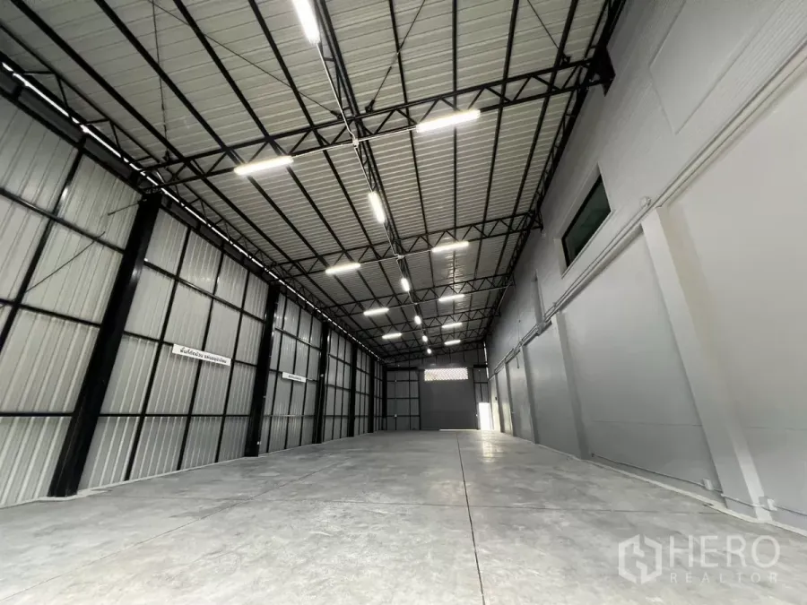 Warehouse for rent in Yan Nawa, Bangkok - High-ceiling warehouse interior with steel truss roof, bright LED lights and smooth concrete floor.