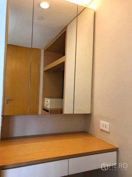 Condominium for rent in Watthana, Bangkok - Bedroom with walk-through dressing area and glass wall looking into the bathroom.