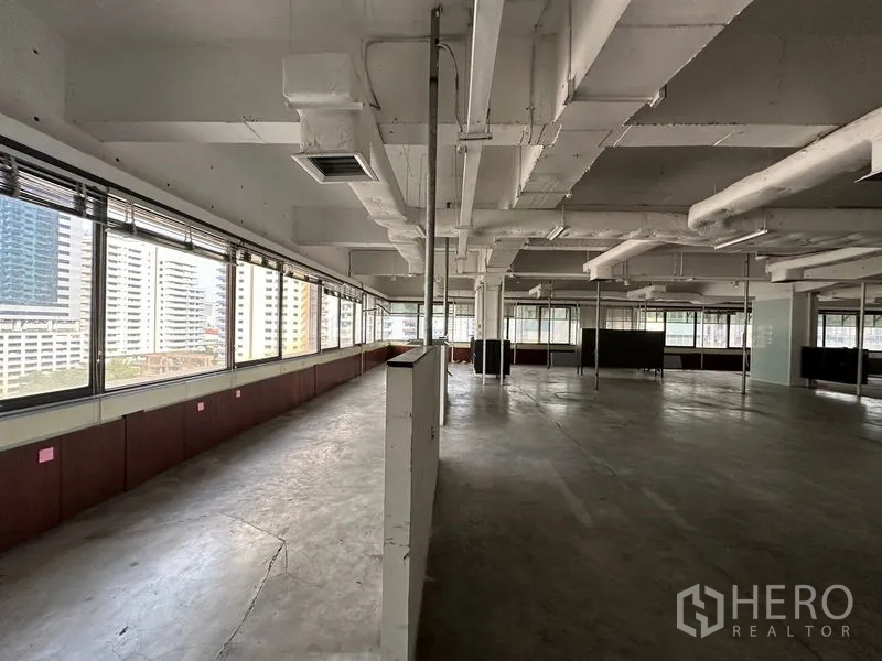 办公空间 出租在Watthana, Bangkok - 大面积开放式平层，落地窗享城市景观，工业风外露天花。