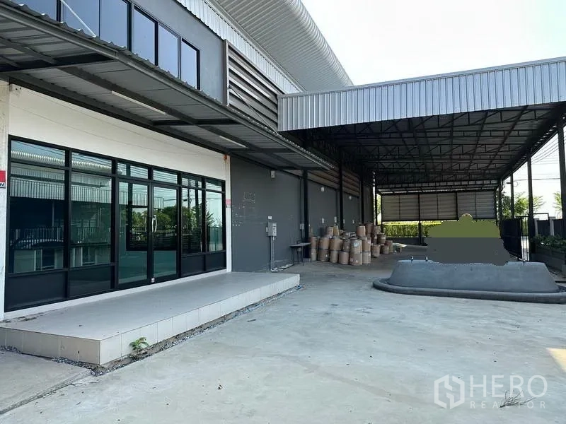 Factory for rent in Samut Prakan - Large covered loading area and platform beside the factory facade.