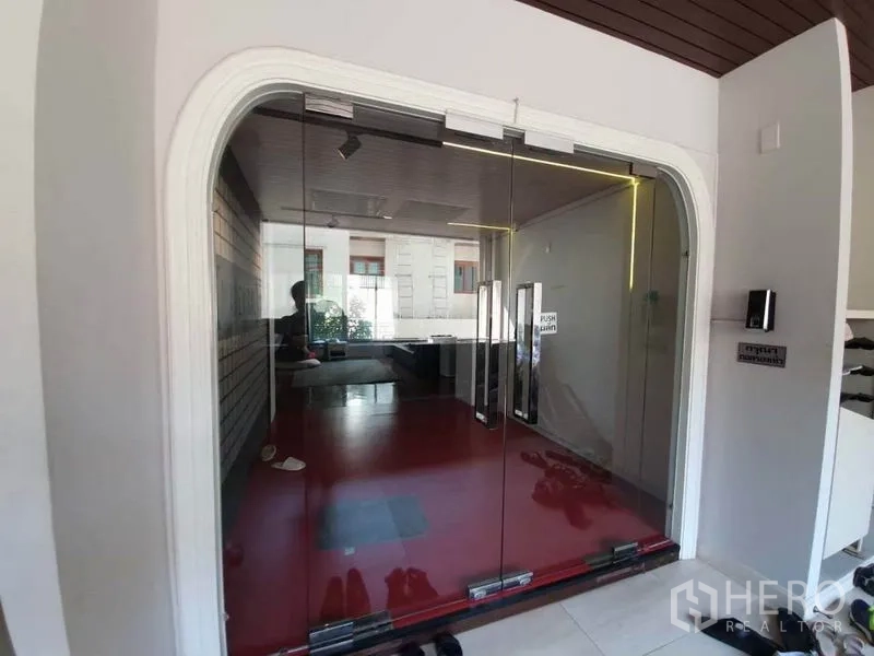 办公空间 出租在Khlong Toei, Bangkok - 玻璃推拉门入口，通往带红色地面的现代大厅。