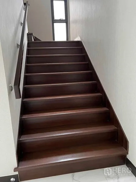 Detached House for sale in Bang Kruai, Nonthaburi - Wooden staircase with handrail leading to the upper floor.