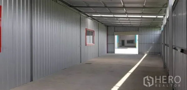 Warehouse for rent in Bang Yai, Nonthaburi - Covered loading corridor with metal cladding, side windows and concrete flooring.