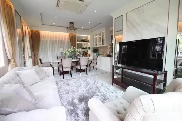 独立式住宅 出租或出售在Lat Phrao, Bangkok - 采光充足的客餐厅，一体化布局，吊灯、大屏电视与柔软地毯。