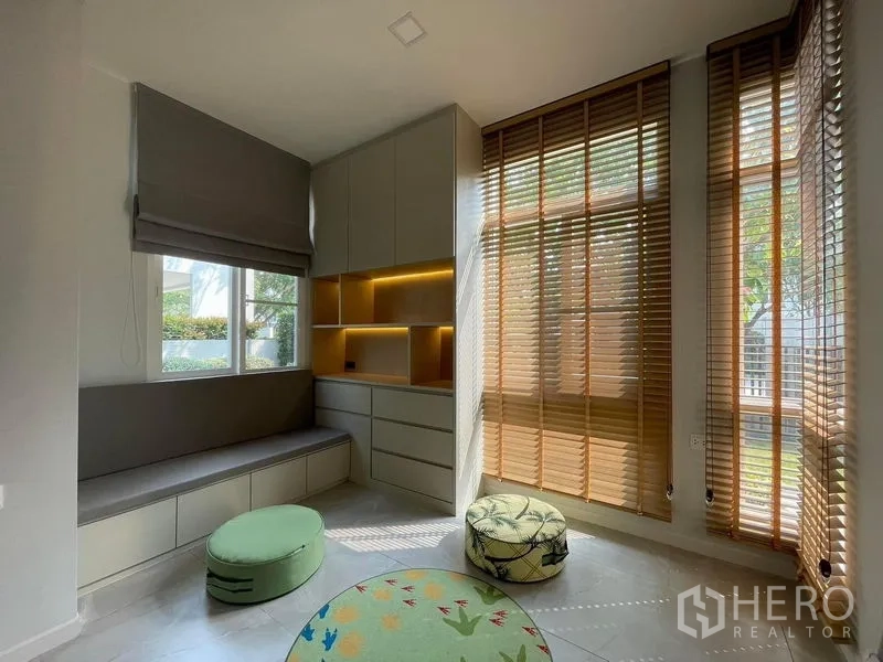 Detached House for rent in Prawet, Bangkok - Sunlit study or IT corner with window bench seating, built‑in storage and tall wooden blinds overlooking the garden.