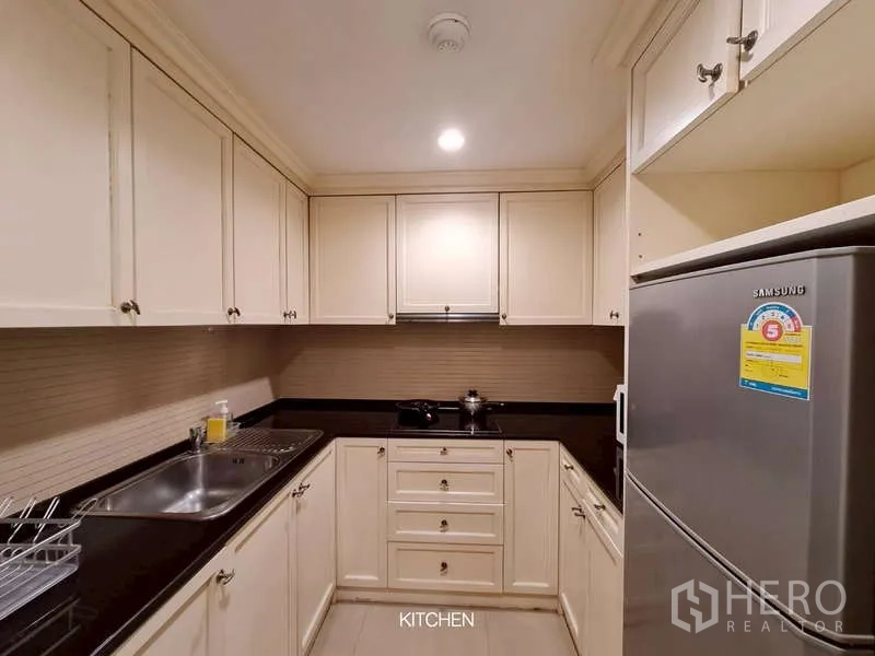 Retail Space for rent in Watthana, Bangkok - Compact service kitchen with cream cabinetry and black countertops