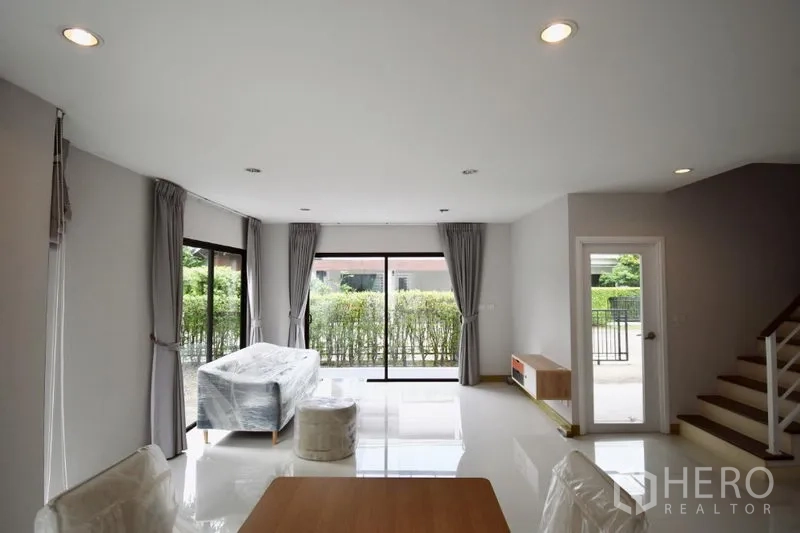 บ้าน ให้เช่าในPrawet, Bangkok - ห้องนั่งเล่นกว้าง ประตูกระจกบานเลื่อนออกสู่ลานด้านนอก รายล้อมด้วยพุ่มไม้