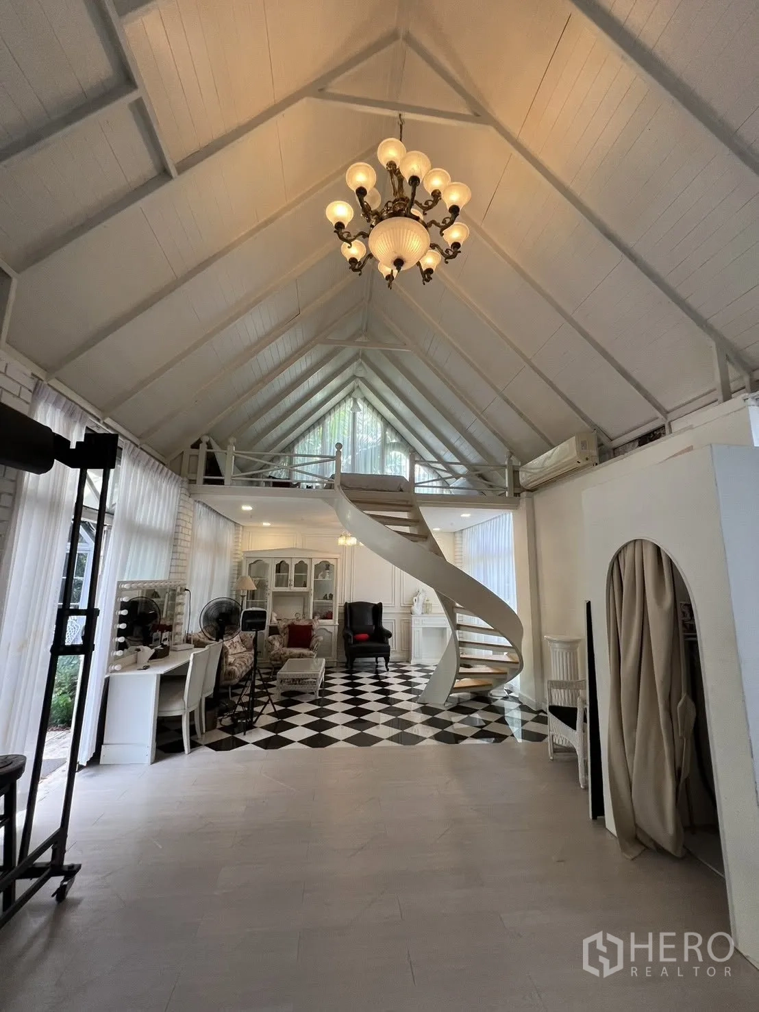 Detached House for rent in Phra Khanong, Bangkok - Spacious hall with chandelier, tall curtains and a workstation area.