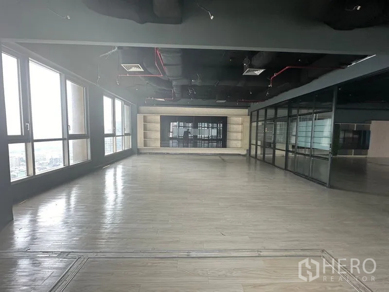 Office Space for rent in Bang Rak, Bangkok - Open room with wall shelving feature and surrounding glass partitions.