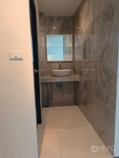 Retail Space for rent - Contemporary washroom with stone-look wall tiles, vanity sink and mirror.