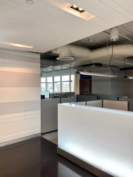 Office Space for rent in Khlong Toei, Bangkok - Reception counter and partitioned workstations in a modern office with large windows and exposed ducting.