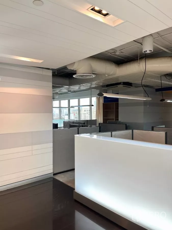 Office Space for rent in Khlong Toei, Bangkok - Reception counter and partitioned workstations in a modern office with large windows and exposed ducting.