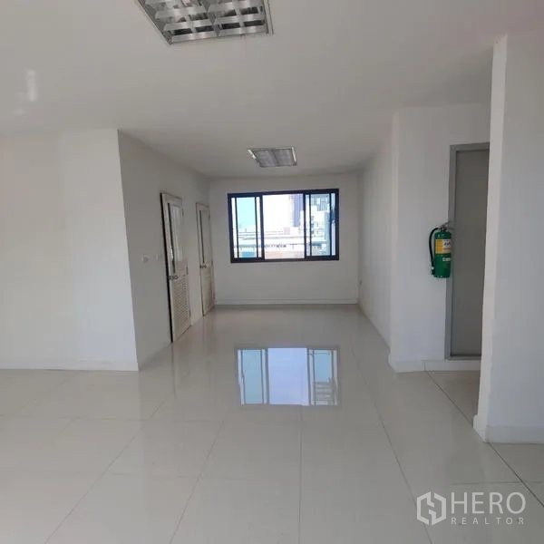 Office Space for rent in Bang Kho Laem, Bangkok - Office corner with window, utility doors and wall-mounted fire extinguisher.