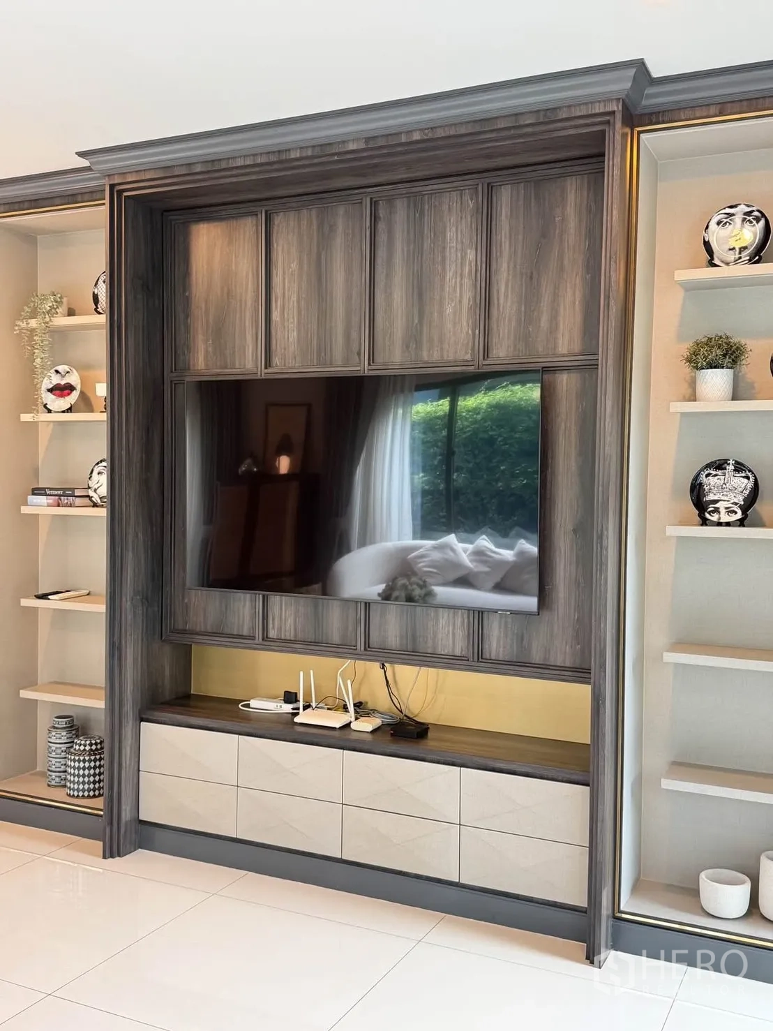 Detached House for rent in Bang Kapi, Bangkok - Built-in TV wall with wood panels, shelving, and a large flat-screen.