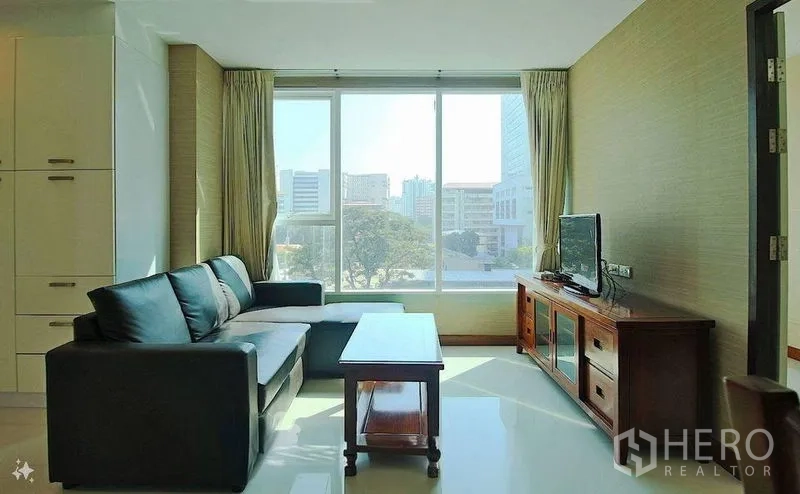 公寓 出售在Watthana, Bangkok - 从另一角度展示明亮客厅，沙发、电视柜与全景窗。