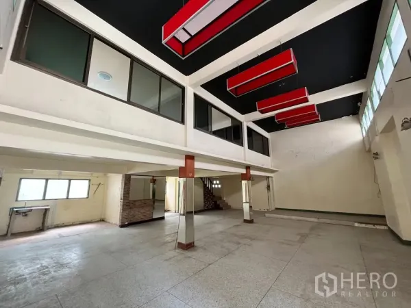 Detached House for rent in Suan Luang, Bangkok - Double-height open hall with mezzanine windows and red ceiling light boxes.