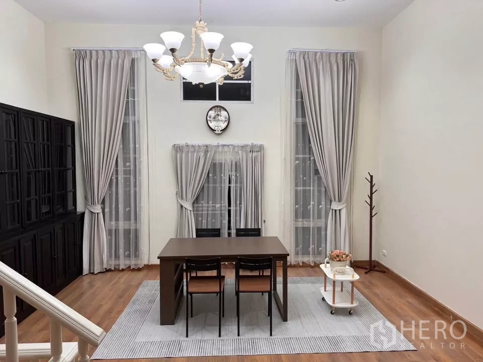 Townhouse for rent in Bang Kho Laem, Bangkok - Dining or meeting room with high ceilings, chandelier, tall curtains and a table set.