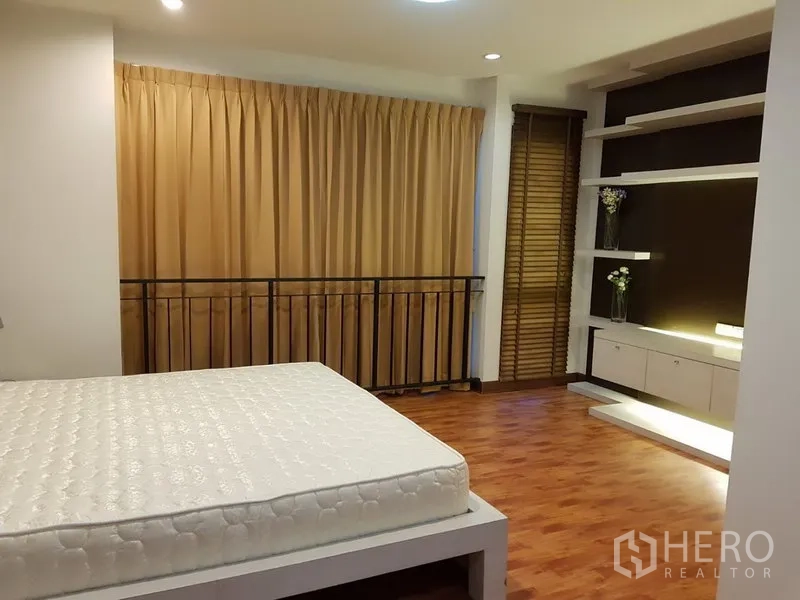联排别墅 出租在Phra Khanong, Bangkok - 宽敞主卧，木地板、落地窗帘与内置展示架