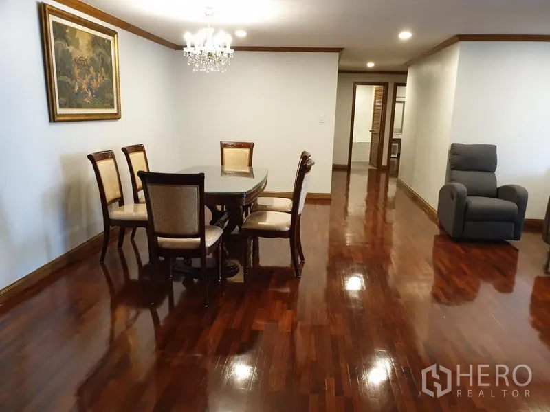 公寓 出租在Watthana, Bangkok - 正式用餐区，六人餐桌、水晶吊灯与通往走廊的空间。