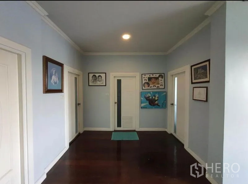 Detached House for sale in Sai Mai, Bangkok - Upstairs landing with light blue walls, multiple doors and polished wood floor.