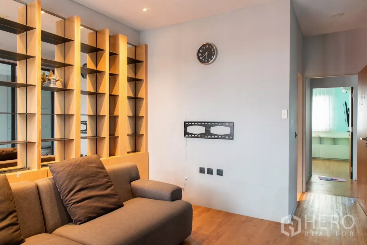 Townhouse for rent in Lat Phrao, Bangkok - Living area from another angle with feature shelving and TV mount.
