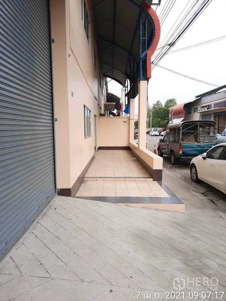 Factory for rent in Bang Bua Thong, Nonthaburi - Covered tiled loading platform beside the roller shutter along the street.