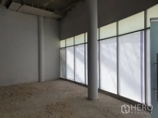 零售空间 出租在Khlong Toei, Bangkok - 空置店铺内部，整面磨砂落地玻璃与结构柱，等待定制装修。